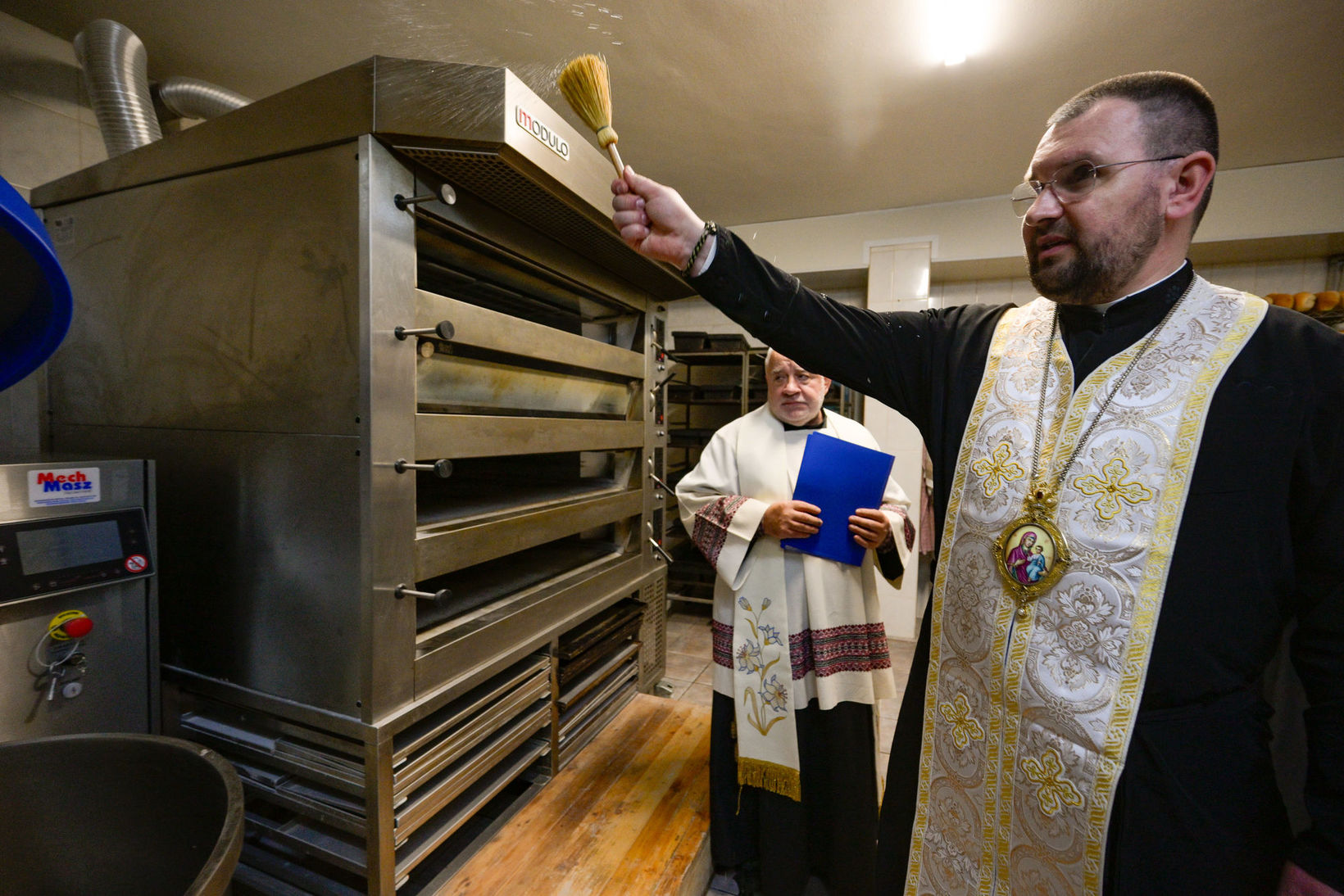 Владика Максим Рябуха та брат Максиміліан Шмігельський під час освячення тістоміса в пекарні Братів-альбертинців. Запоріжжя, 8 листопада 2025 року.